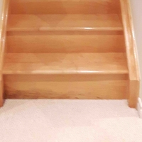 Before: Basement flood stained and water damaged the bottom riser of the stairs